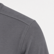 Close-up of a gray blazer shoulder seam with neat stitching and smooth fabric detail