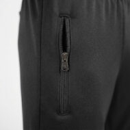 Close-up of a black fabric with a vertical zippered pocket and metal zipper pull on the side of a garment.