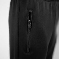 Close-up of a vertical zipper on black pants, pocket zipper closed with a metal pull.