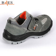 Gray safety sneaker with a Velcro strap, orange inner lining, and rugged tread sole.