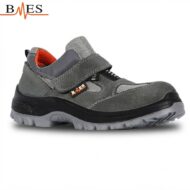 Gray work shoe with velcro strap and rugged outsole, designed for safety and durability (side view).