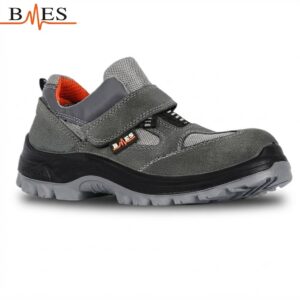 Gray work shoe with velcro strap and rugged outsole, designed for safety and durability (side view).