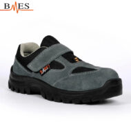 Grey and black children's Velcro sneaker with a thick tread sole and orange logo tag on the side.