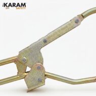 Close-up of a metal clamp joint with rivets and curved tubing, part of a safety mechanism.