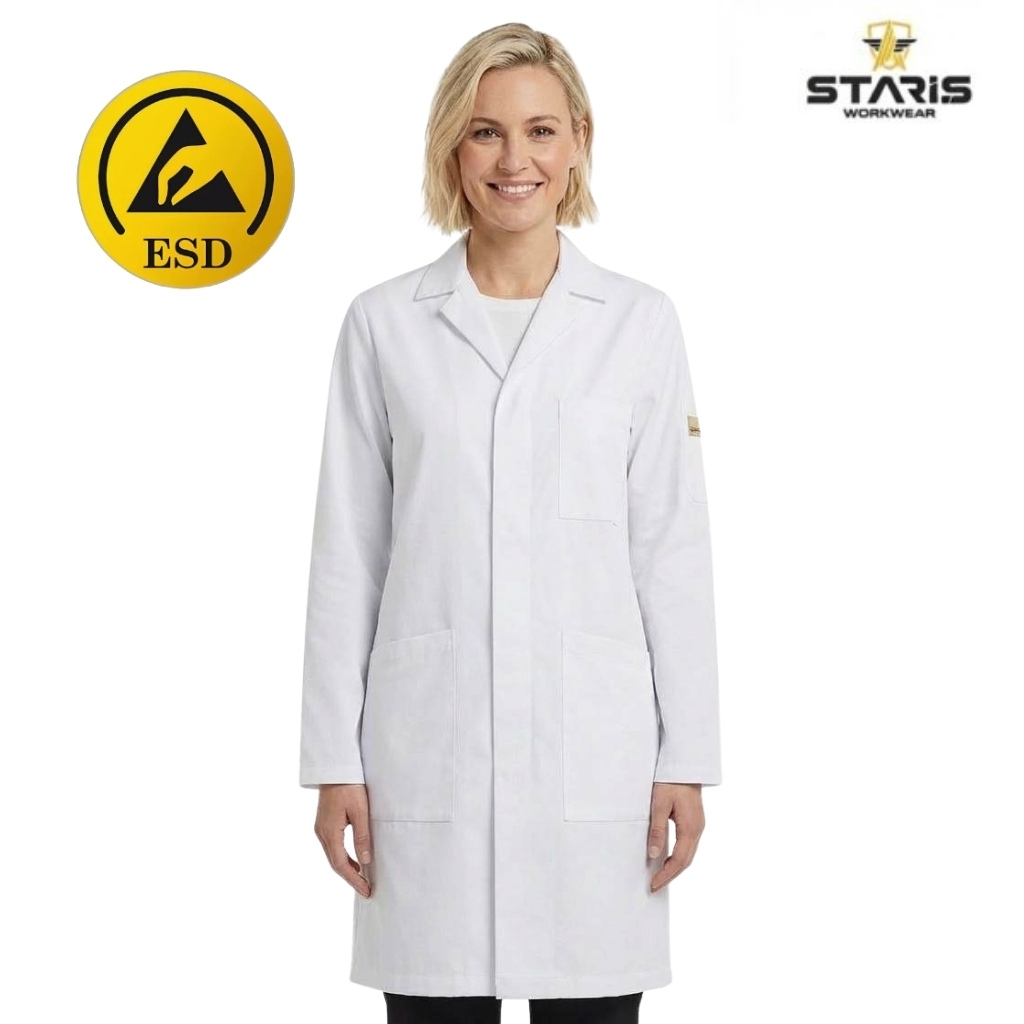 Smiling woman in a white lab coat, standing with hands at her sides; ESD yellow safety symbol on the left and the Staris Workwear logo on the right.