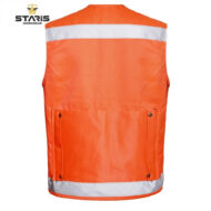 Back view of orange high-visibility safety vest with reflective silver bands across the top and bottom, featuring two side pockets; Staris Workwear logo shown in the corner.