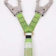 Industrial fall-arrest lanyard with two metal carabiners and lime-green webbing connected to a shock-absorbing pouch.