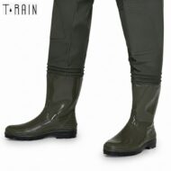 Glossy olive-green knee-high rain boots on a person, with pants tucked into the tops, shown from the side.