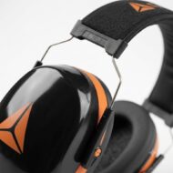 Close-up of black and orange over-ear headphones with padded ear cups and metal headband detail.