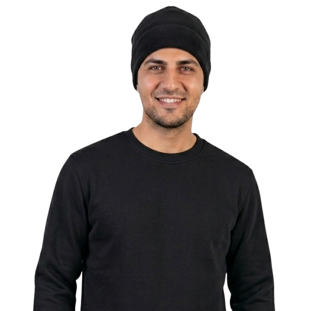 Smiling man in a black beanie and black long-sleeve shirt, facing the camera against a white background.