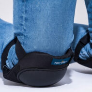 Close-up of a black Portwest safety boot with padded ankle support worn over blue jeans.