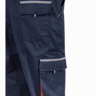 Close-up of dark blue cargo pants showing front and thigh pockets with reflective trim on the flap and seam details, indicating a workwear design.