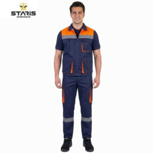 Model wearing Staris workwear: navy blue protective outfit with orange panels, multiple pockets, and gray reflective bands on the lower legs, black shoes.