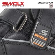 Close-up of a black leather safety boot with a metal buckle and Swolx logo badge.