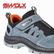 Close-up of a blue and black SWALX safety footwear shoe with orange interior and gray Velcro strap, showing rugged sole.