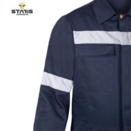 Dark blue Staris workwear shirt with white reflective stripe across chest and on sleeve, chest pocket visible, partial logo in corner.