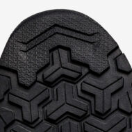 Close-up of black tire tread with a geometric, interlocking pattern.