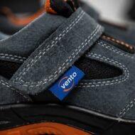 Close-up of a dark blue suede sneaker with a Velcro strap and a blue VentO tag visible on the side.