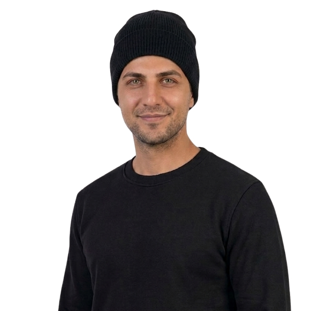 Man wearing a black knit beanie and black long-sleeve shirt, smiling slightly, against a white background.
